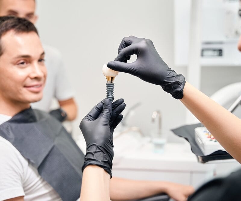 Aesthetic stomatology client watching at process of dental implant installation