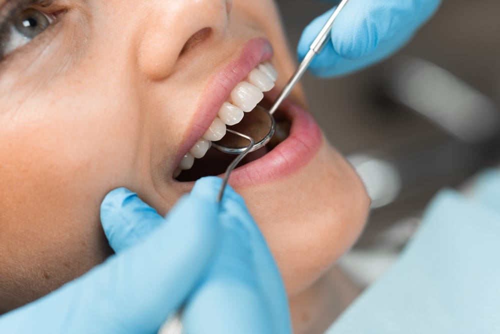 Close-up of a girl's smile, oral diagnostics by a dentist close-up. The dentist works closely on the treatment of the patient's teeth, using a microscope for maximum accuracy and detail. This process