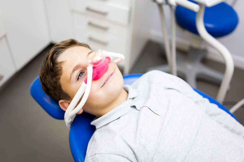 Child resting comfortably in a dental chair with nasal sedation, demonstrating gentle and stress-free pediatric dental care - Berry Hill Dentist